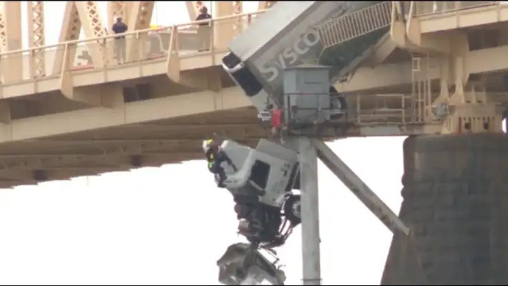 Crash leaves truck dangling over bridge in US, driver pulled to safety