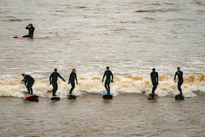 Surfers ride huge Severn Bore tidal wave in Gloucestershire